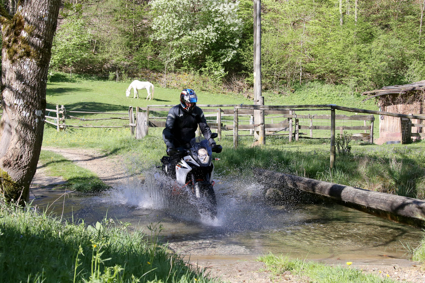 Motorrad durchfährt mit Gischt eine Furt bei Schelklingen Motorrad durchfährt mit Gischt eine Furt bei Schelklingen